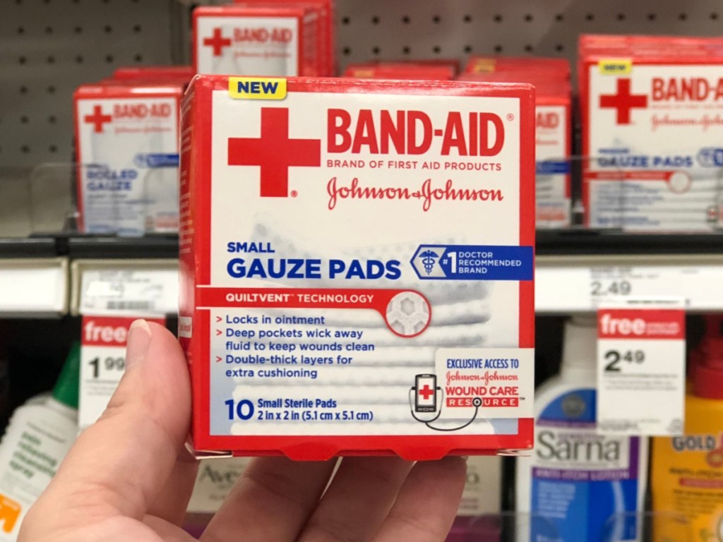 hand holding band-aid brand gauze pads inside a store