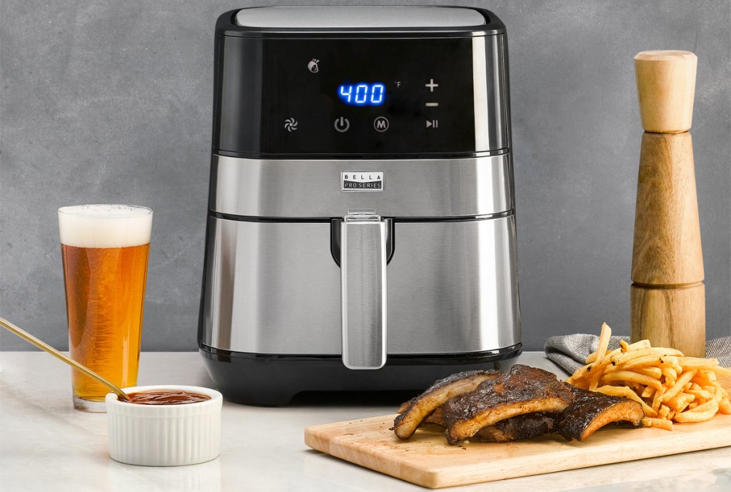 stainless steel and black air fryer with ribs, fries, and beer