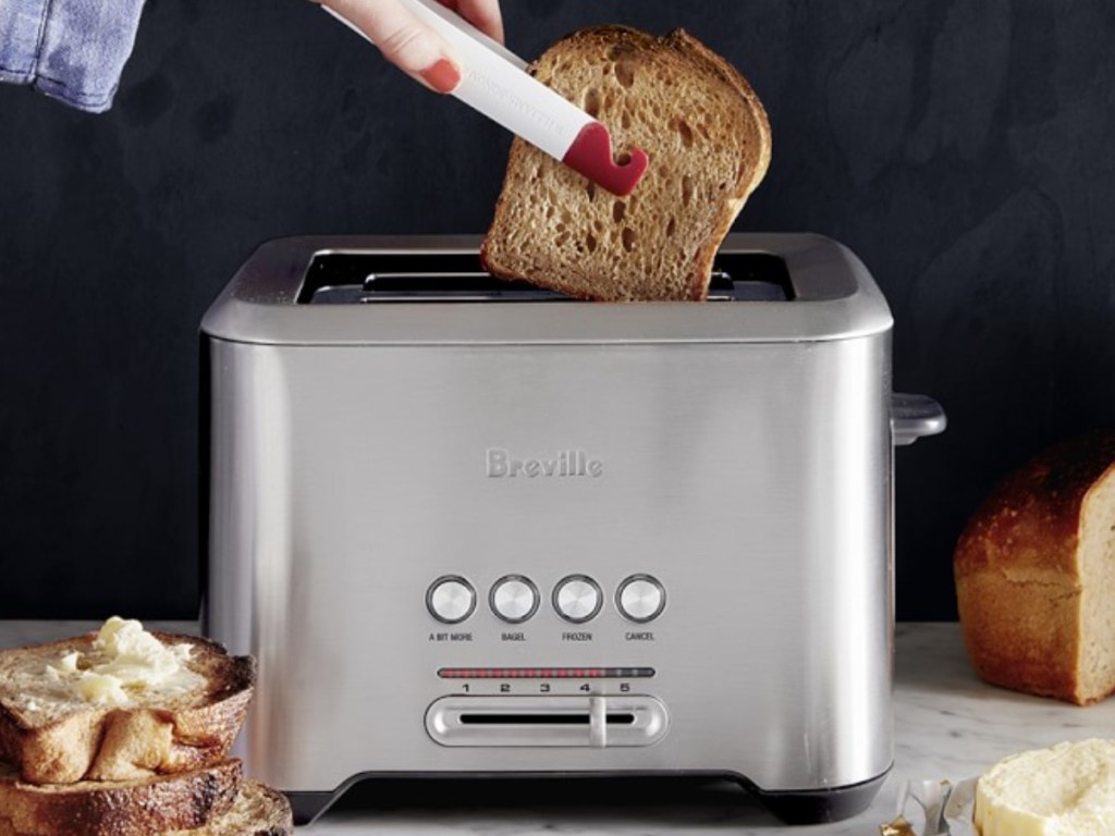 woman taking toast out of a toaster