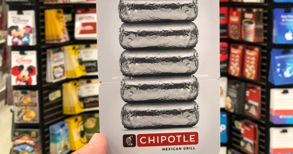 hand holding Chipotle gift card in front of gift card display in store