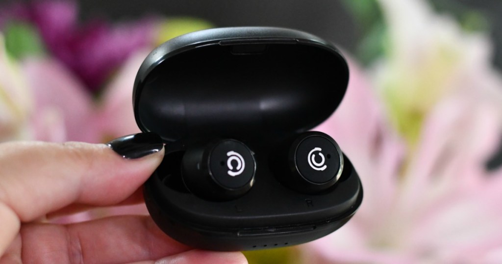hand holding a pair of wireless earbuds in a case