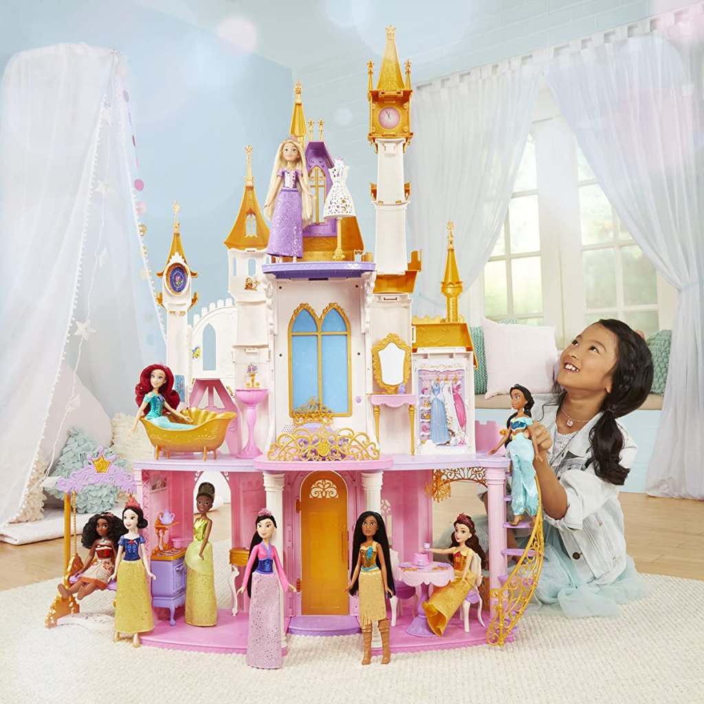 girl sitting next to a Disney Princess Ultimate Castle