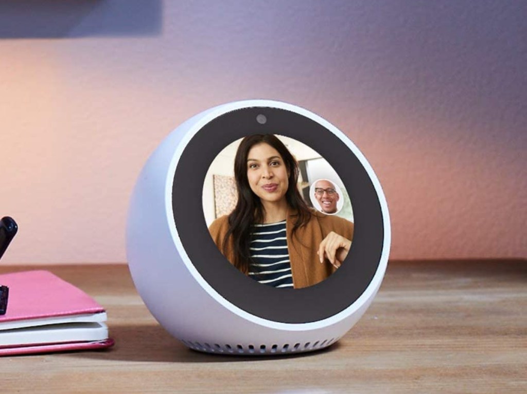 man video chatting with woman on smart alarm clock on desk