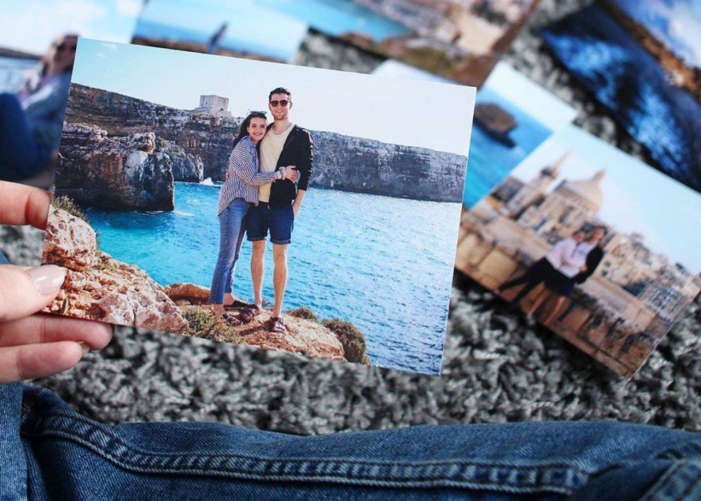 woman holding vacation photos