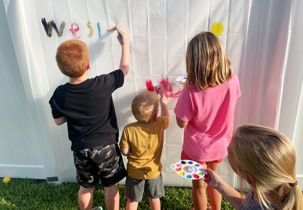 children painting a shower curtain, one of the fun activities for kids
