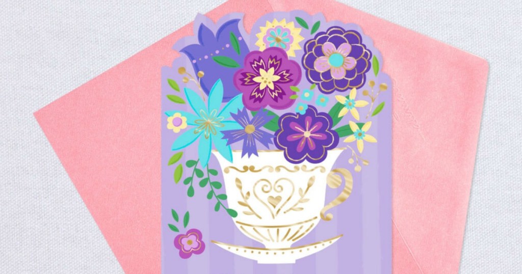 greeting card with teacup full of flowers printed on it and pink envelope