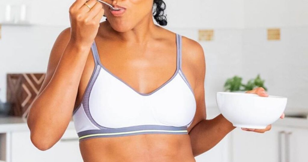 Woman wearing sports bra eating cereal