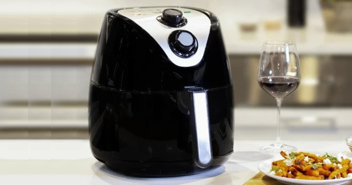 kalorik air fryer in kitchen with wine glass and fried food