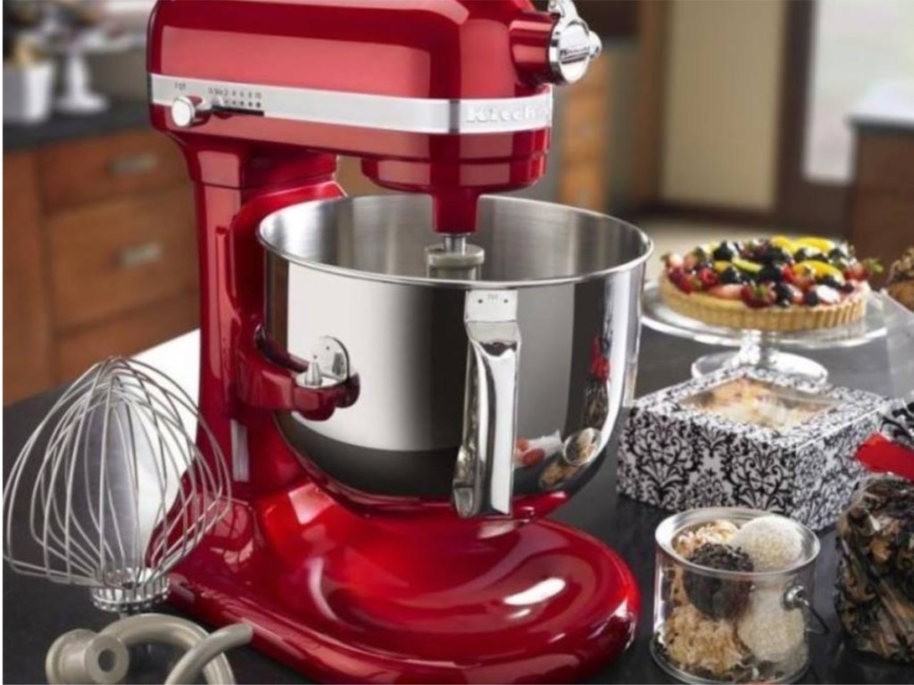 red kitchenaid pro mixer on counter with desserts around