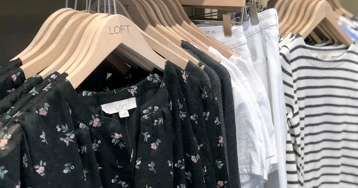 store display rack of black floral blouses and white shorts