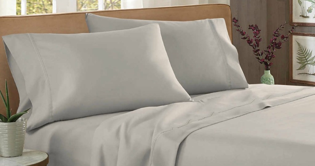 bed with grey sheets and pillows on it