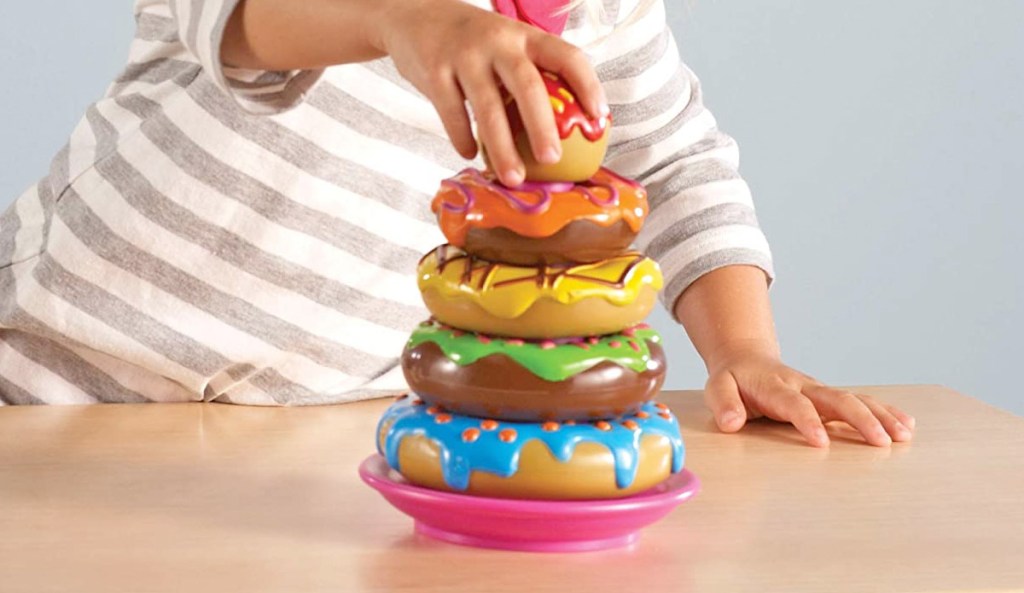 child playing multi-colored doughnut stacking game