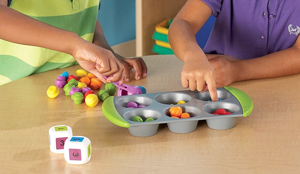 kids sorting small toys into cups of a muffin tin