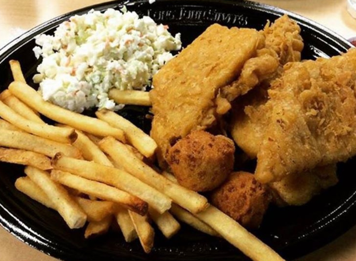 Long john silver platter of food with fish, fries, coleslaw nad hush puppies
