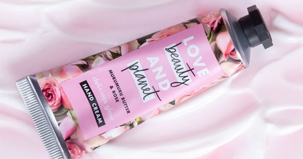 pink bottle of rose hand cream on pink background