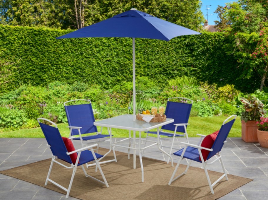 blue patio dining set with 4 chairs, table, and umbrella