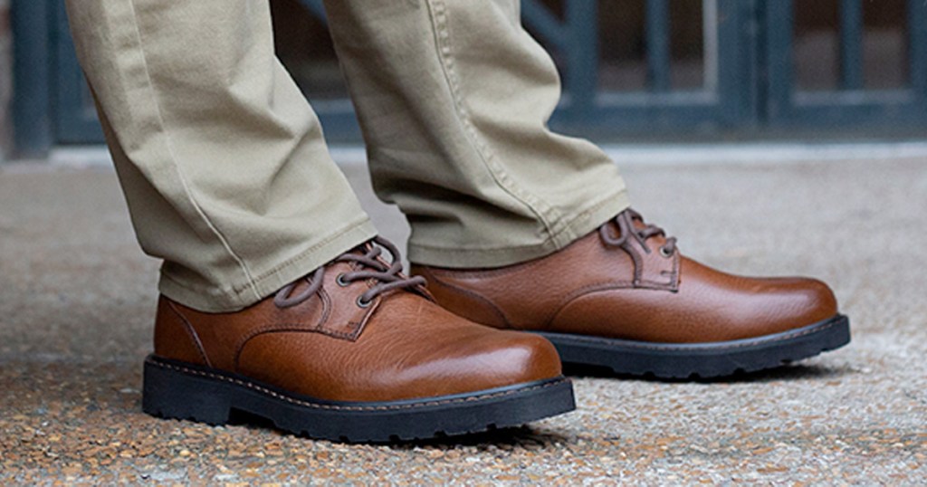 man wearing a pair of brown leather dress shoes with khaki pants