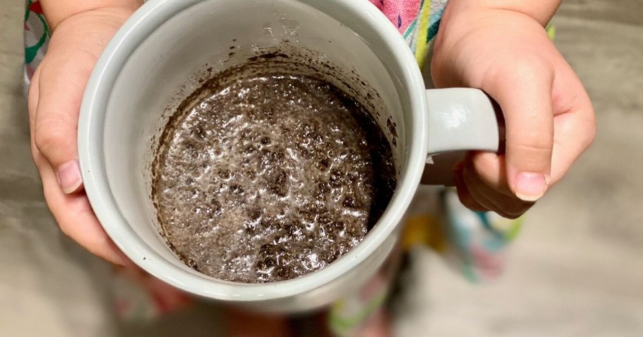 showing how to make oreo mug cake by mixing milk with cookies