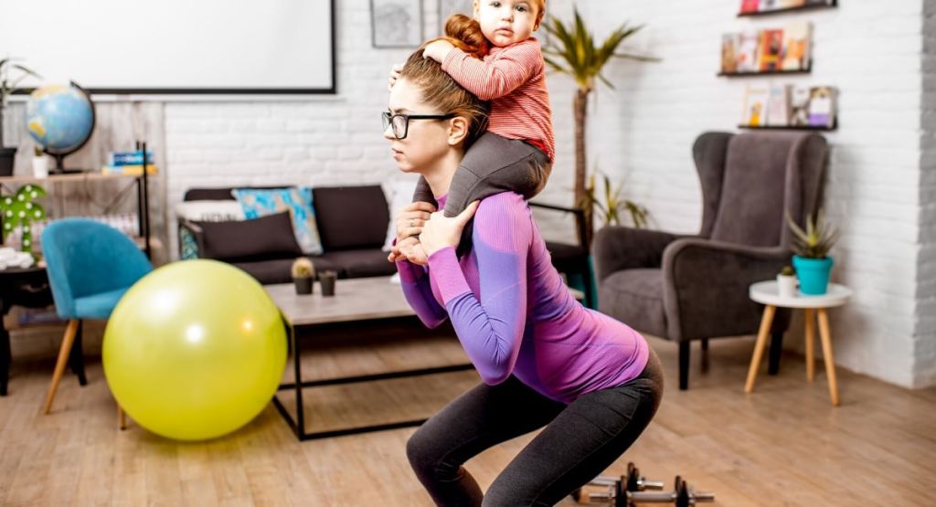 Mom working out at home with baby on shoulders