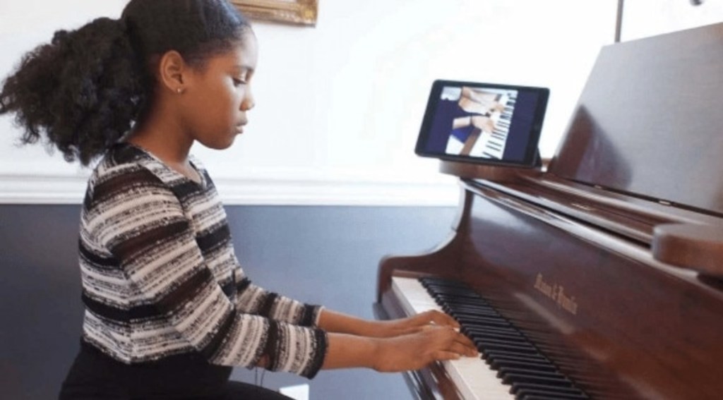 Girl taking an online piano lesson, one of the best indoor fun activities for kids