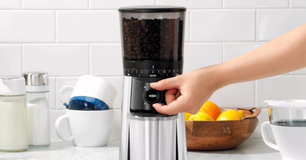woman turning knob on a coffee grinder