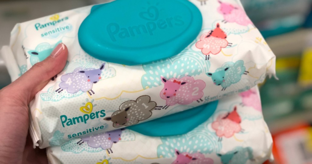 two packs of pampers sensitive wipes in hand