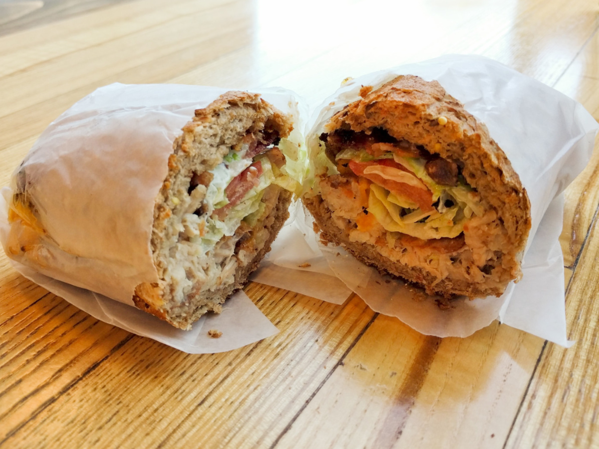 wrapped sandwich with meat and veggies cut in half on table