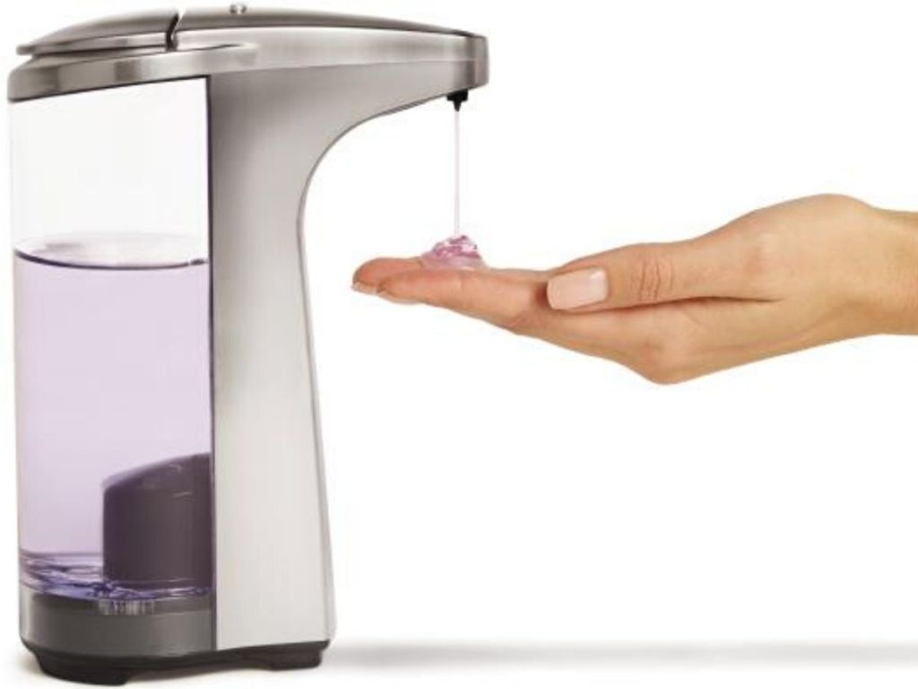 womans hand using touch free soap dispenser