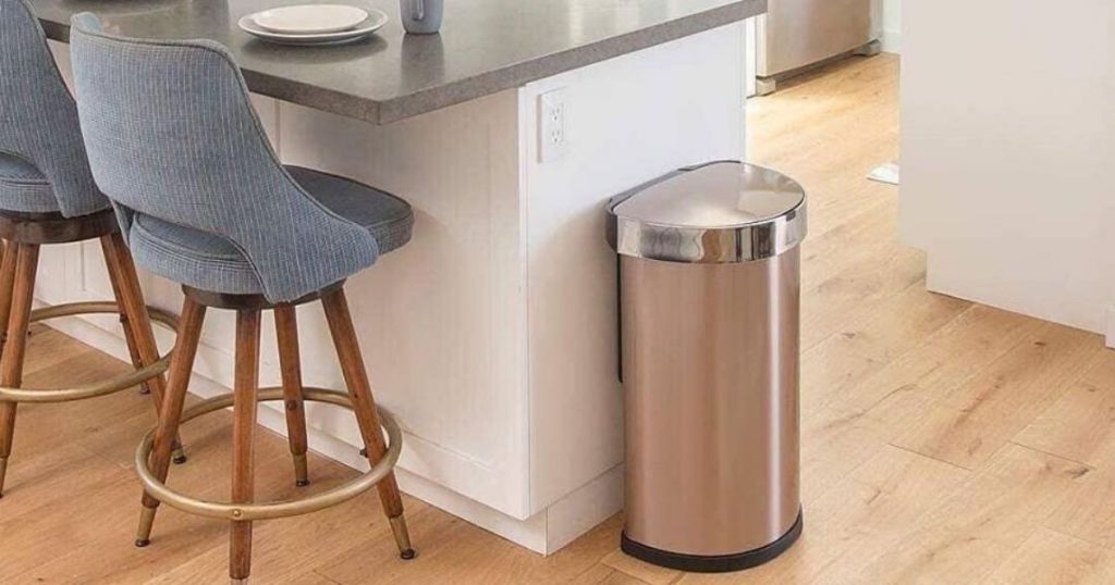 kitchen with touch free metal trash can next to counter with bar stools