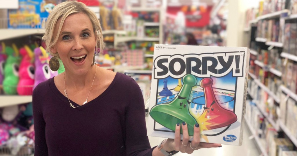 woman with blonde hair holding up the box for sorry classic board game