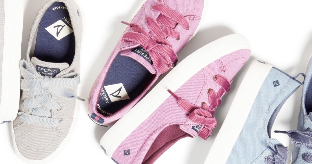 three pairs of canvas sneakers in grey, pink, and light blue