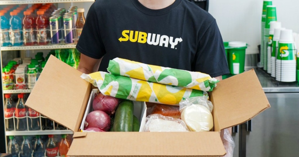 Man holding Subway Grocery box inside restaurant