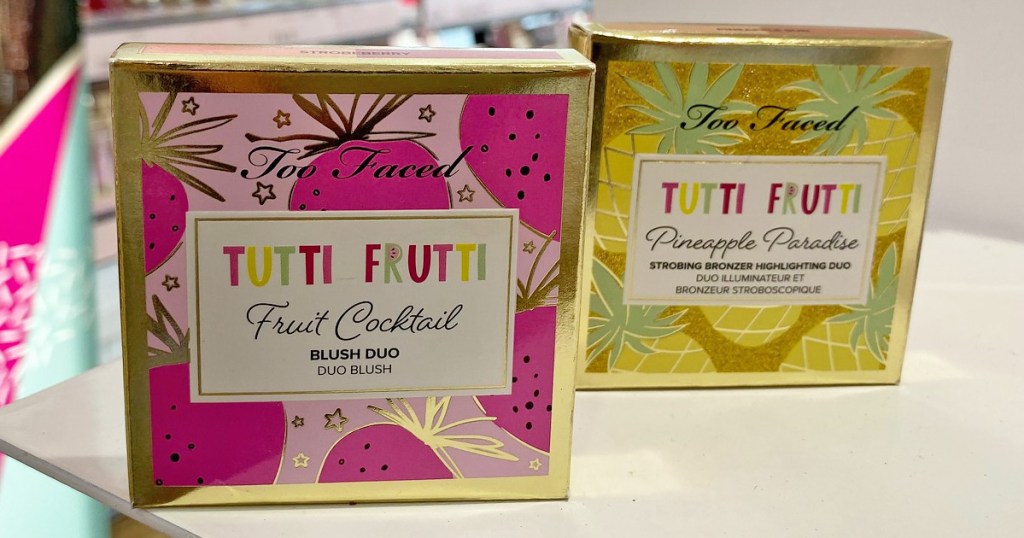 packages of too faced tutti fruity fruit cocktail blush and pineapple paradise bronzer on white table