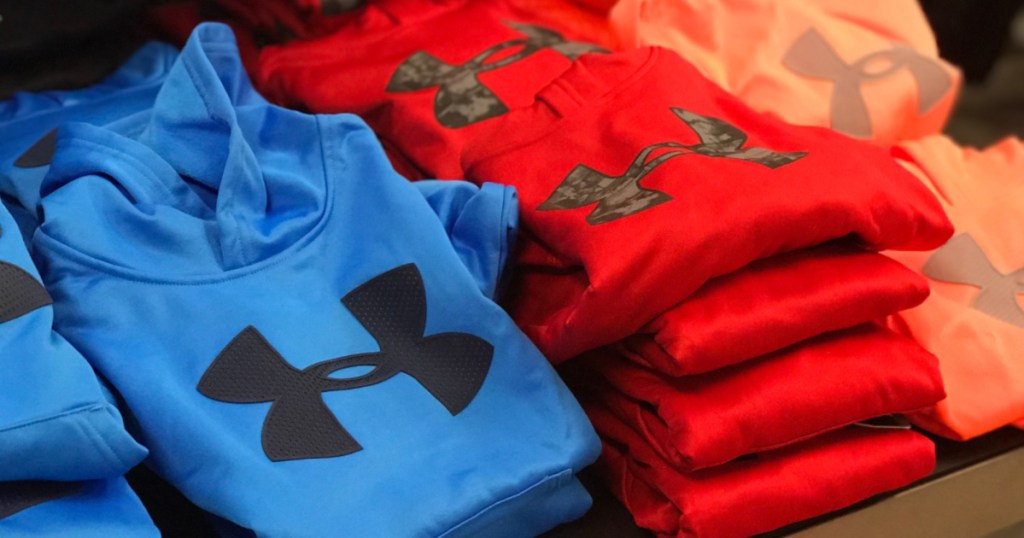 blue, red, and orange sweatshirts with logo on front on store table