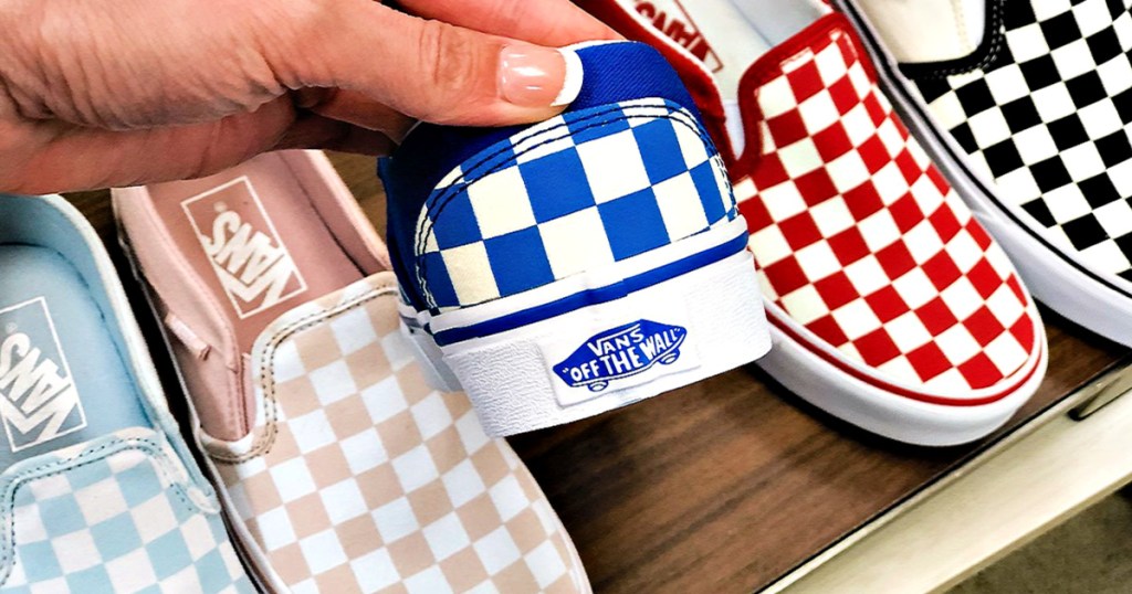 Vans Shoes on shelf with person holding up blue checkered shoes