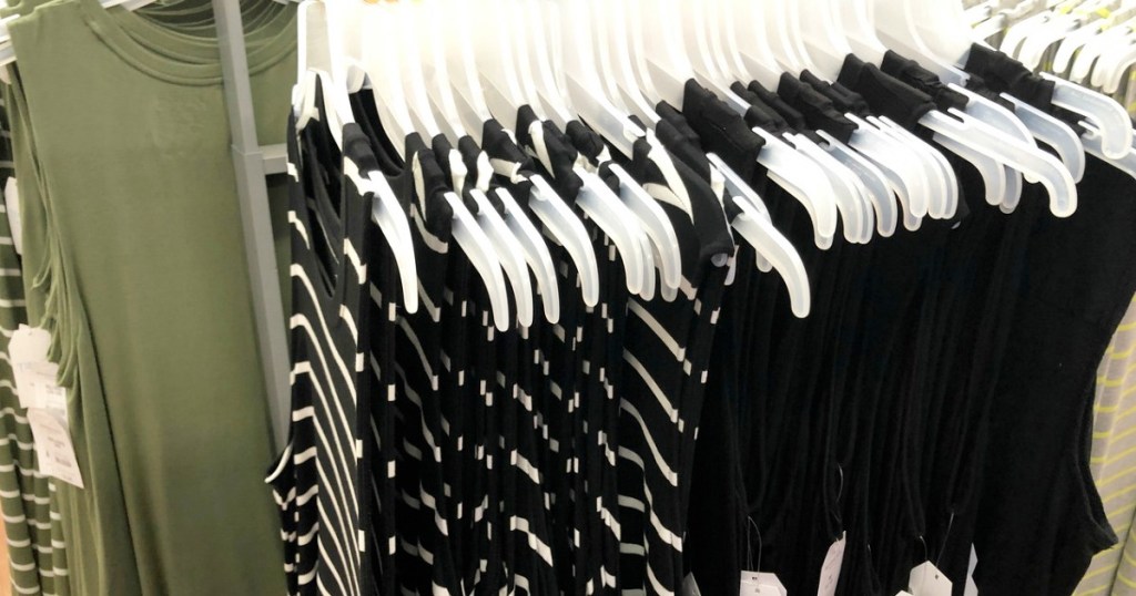 store display rack of sleeveless dresses in olive green, black, and black and white stripes