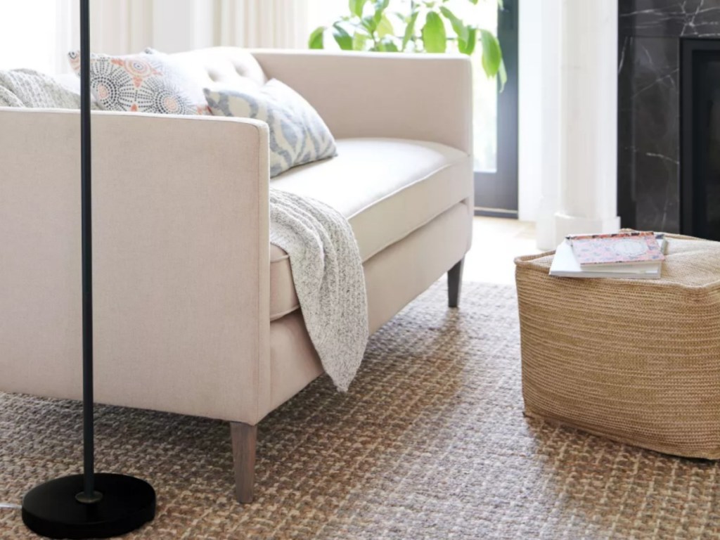 Woven outdoor pouf next to couch