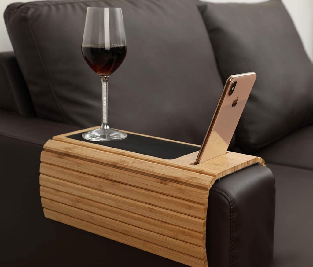 space saving bamboo wood tray on leather couch with wine glass and phone