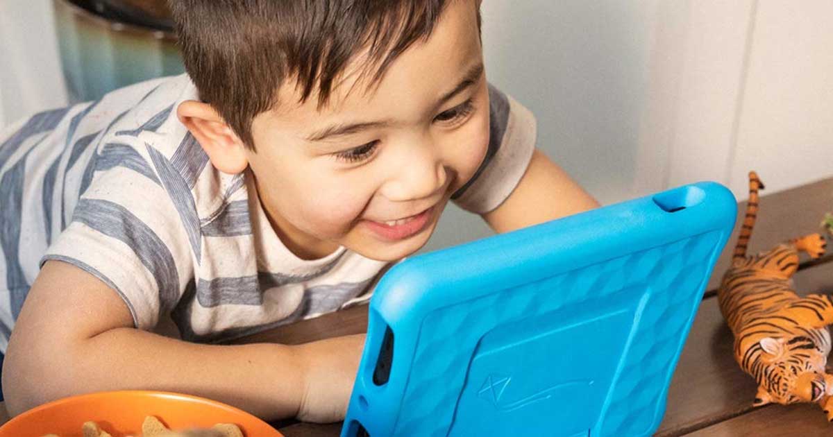 Boy smiling and looking at a tablet