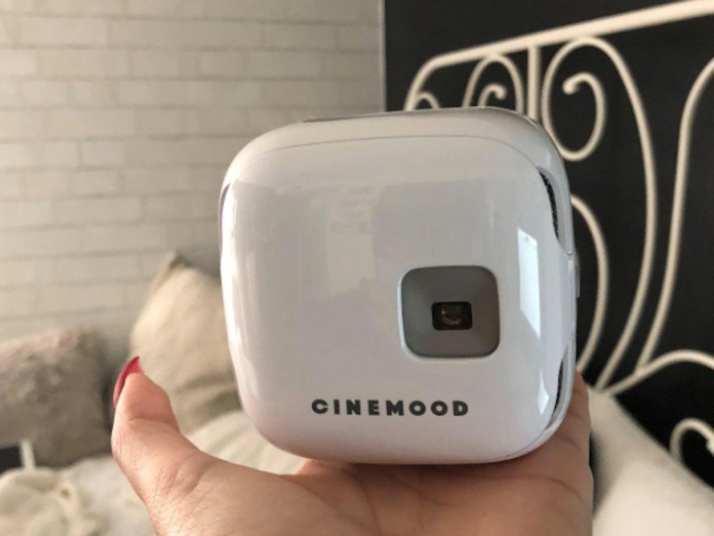 hand holding a white box with cinemood logo on bottom