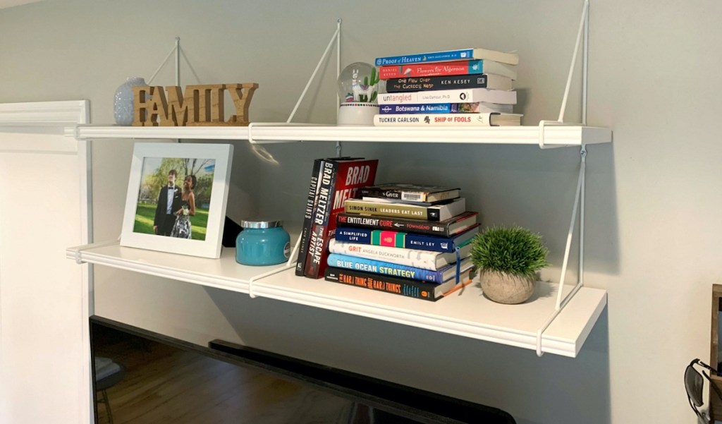 space saving white wall shelves on wall with books and decor