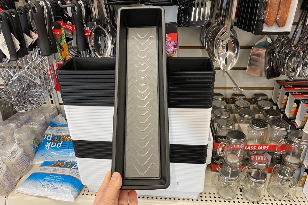 hand holding a black and gray drawer organizer