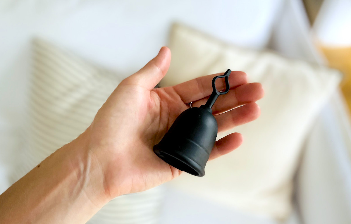 hand holding black menstrual cup