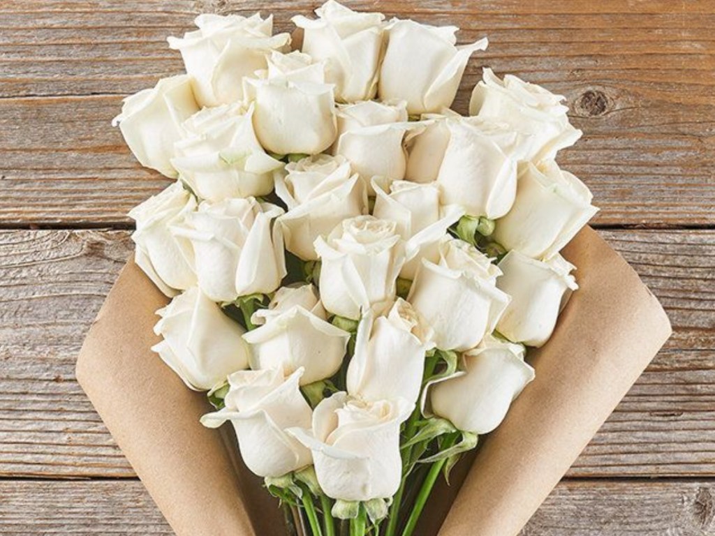 bouquet of white roses wrapped in brown kraft paper