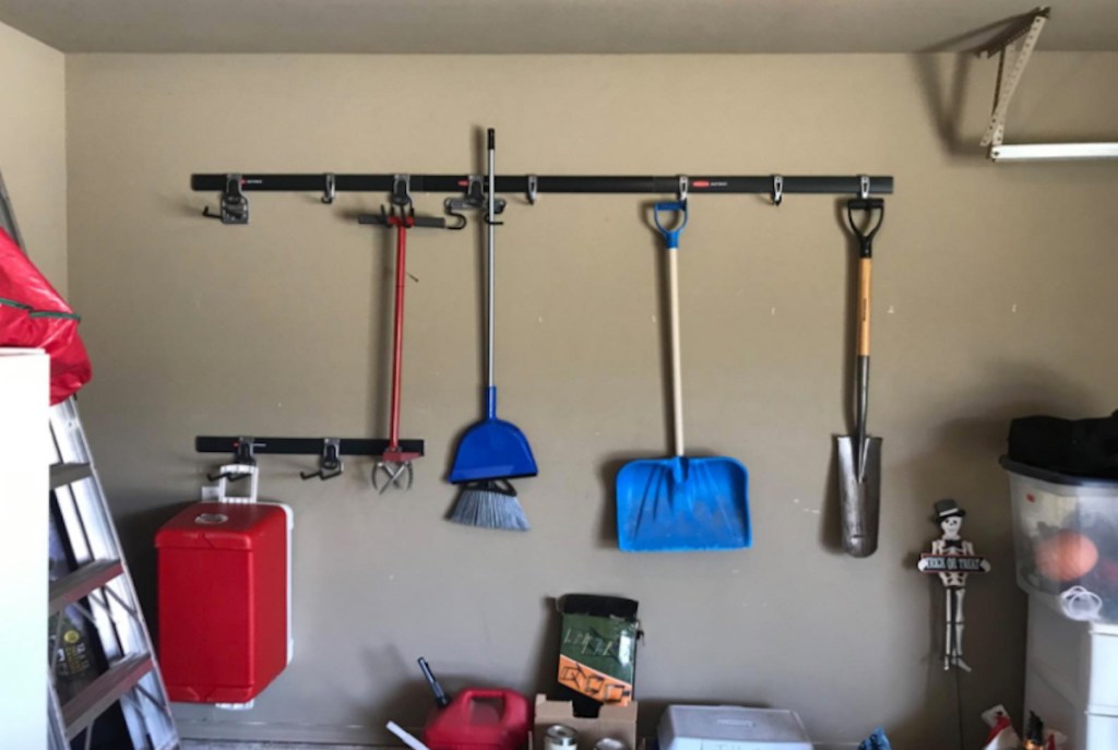 space saving idea of storage organizer on garage wall with yard tools hanging from hooks