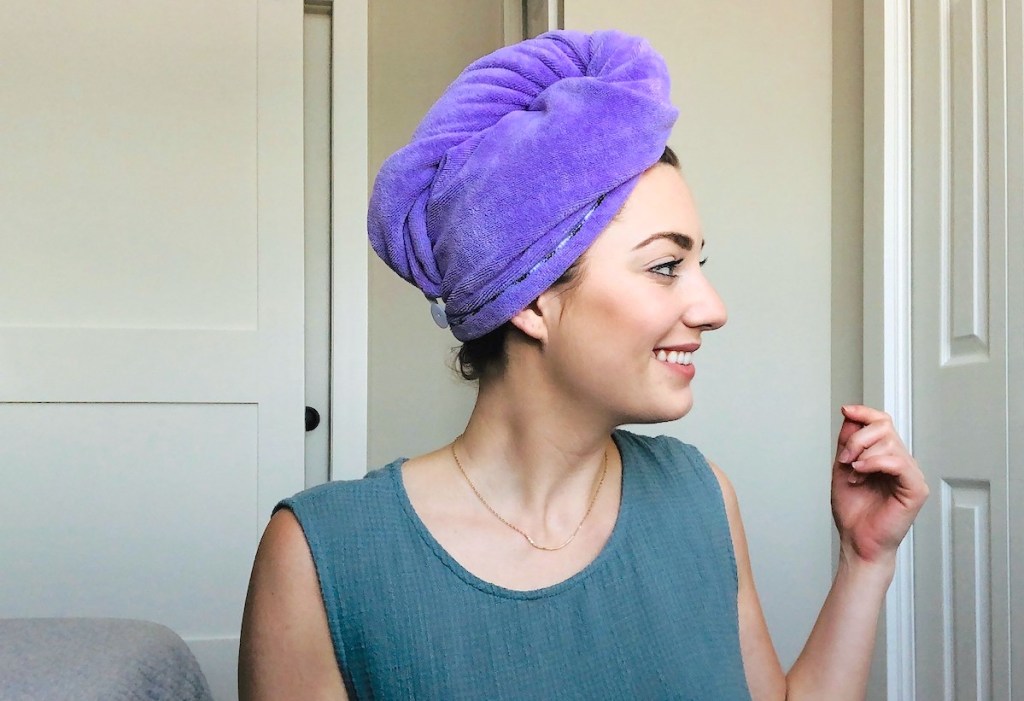 woman smiling turned to side with purple hair towel on head