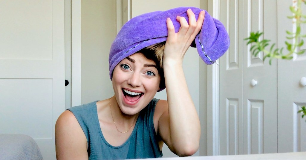 woman with purple hair towel on head looking surprised