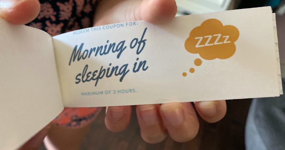 holding Mother's Day coupon book with morning of sleeping in coupon