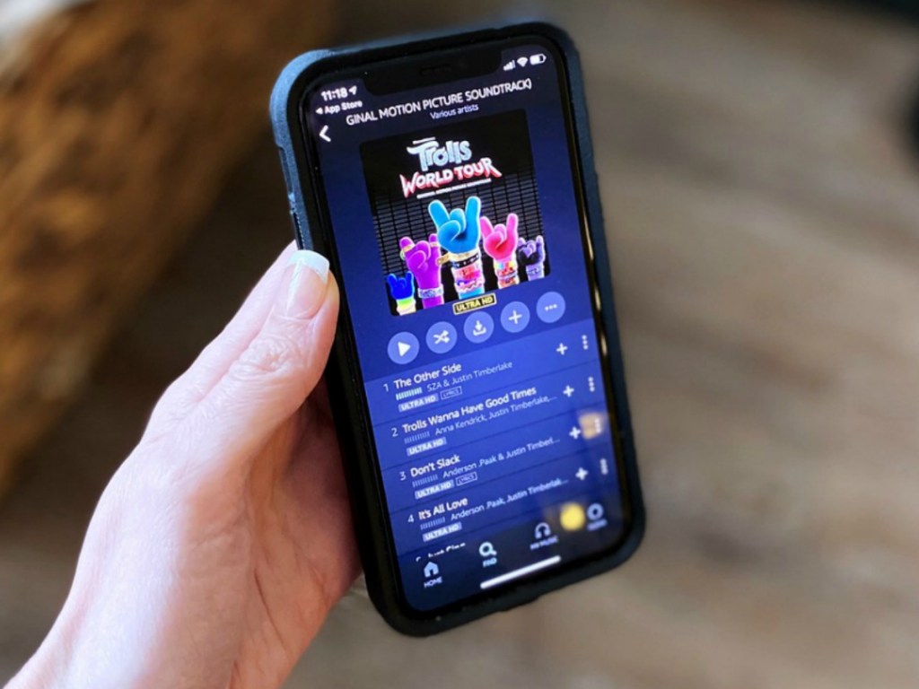 woman's hand holding an iPhone with Amazon Music app open to Trolls soundtrack