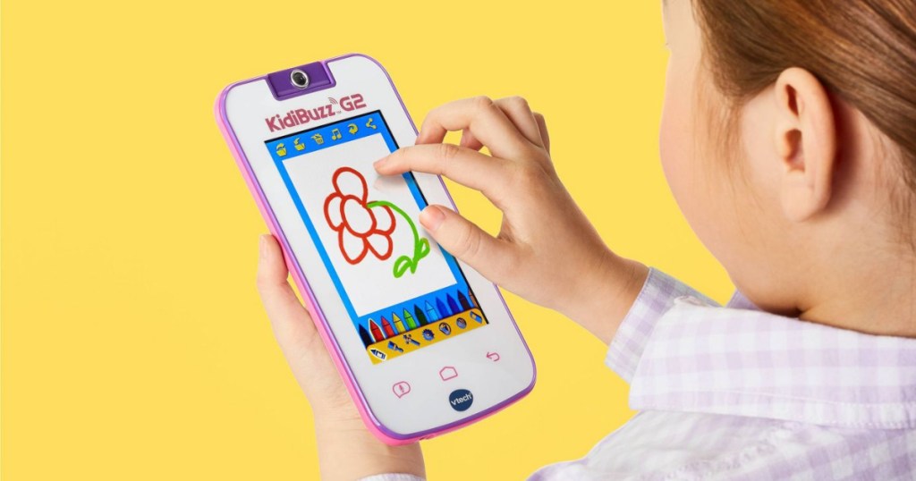 girl playing on her KidiBuzz G2 device with yellow background